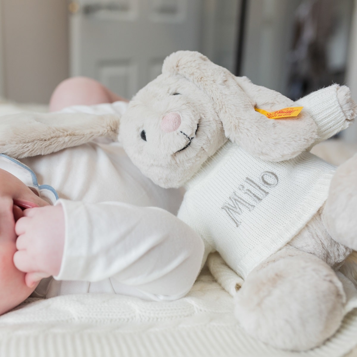 personalised grey milo bunny teddy next to baby