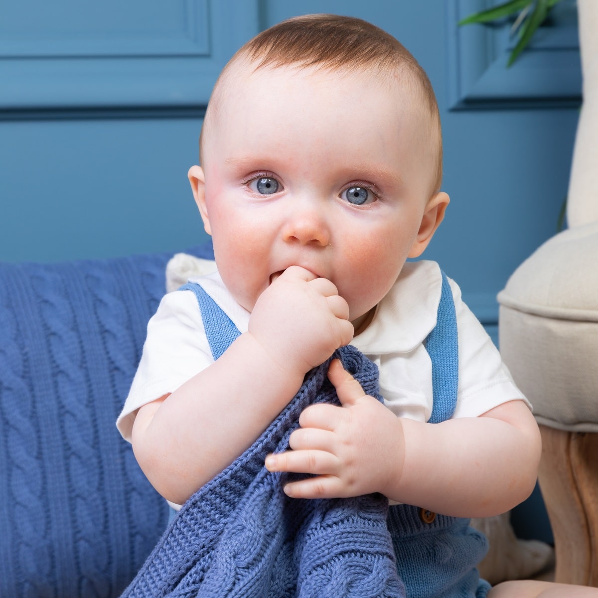 child playing with blue blanket