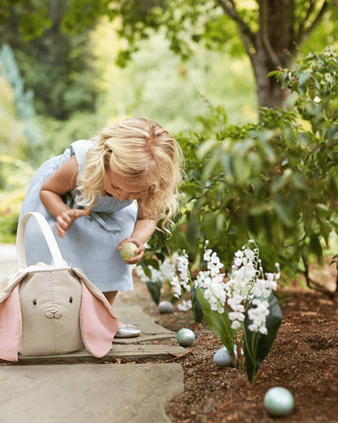 child putting eggs in bunny bag