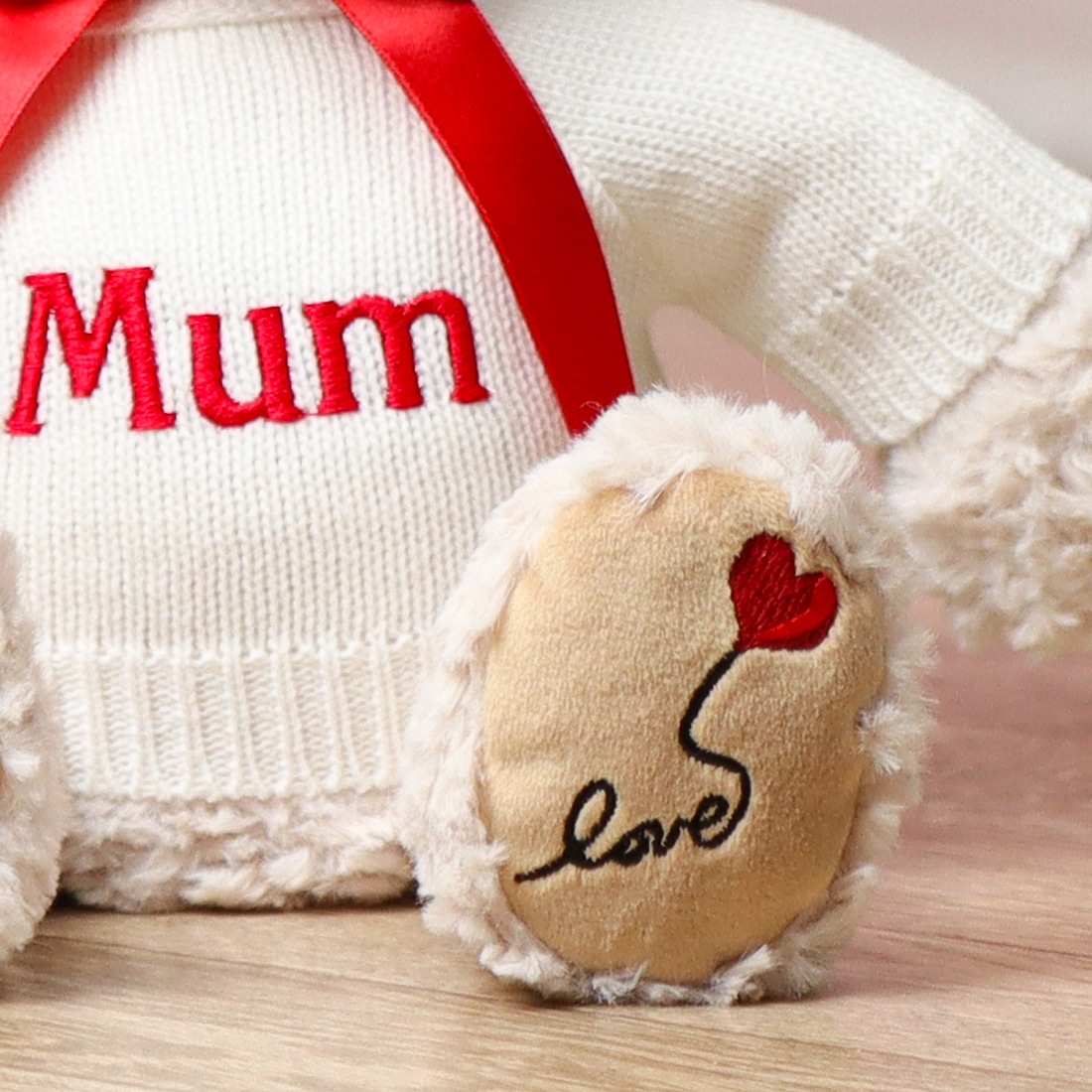 personalised teddy bear with love with a red heart on right foot close up